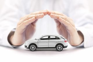 © Jakub Krechowicz - stock.adobe.com Foto: Hände über kleinem Auto
